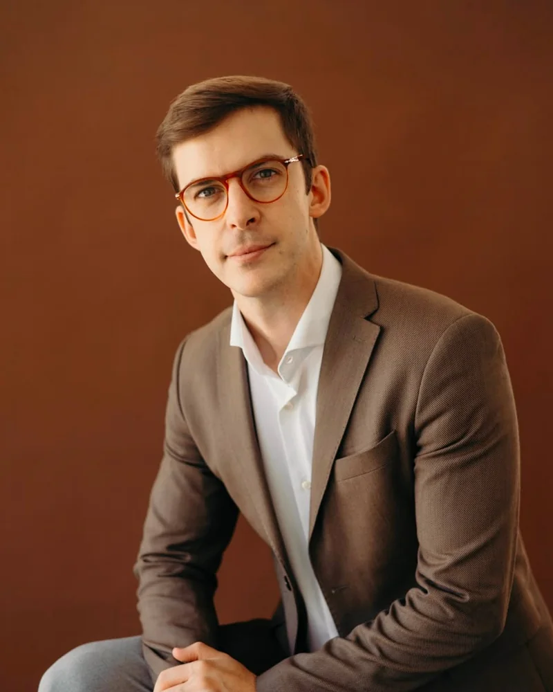 Dr. João Gubert, cirurgião de cabeça e pescoço e microcirurgião, sentado em estúdio