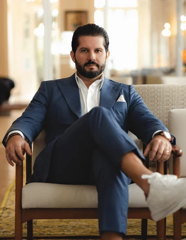Dr. Joaquim Menezes sorrindo, de blazer cinza, sobre fundo claro